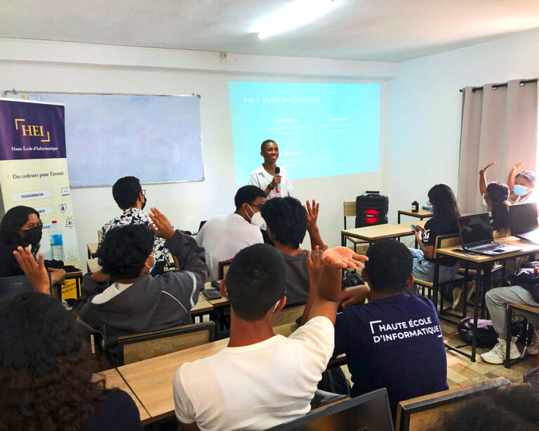 Des étudiants de HEI lèvent la main pour poser des questions pendant un cours